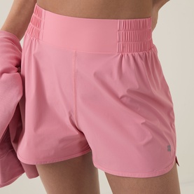 Model wearing Sweaty Betty melrose pink high-waist running shorts with elasticated waistband, styled with matching pink jacket