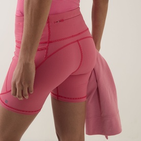 Model wearing Sweaty Betty shorts in Red Micro Stripe Print, high-waisted with side pocket detail, styled with matching pink top.