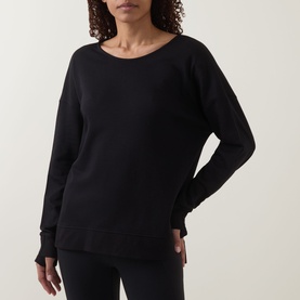 Model wearing Sweaty Betty After Class Open Back Tie Sweatshirt in black, featuring long sleeves with thumb holes