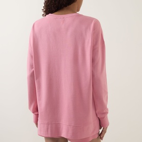 Model wearing pink oversized crew neck sweatshirt, rear view, with matching pink shorts