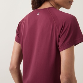 Model wearing Sweaty Betty Merlot Red T-shirt, rear view showing raglan short sleeves and small logo detail at back neck.