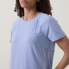 Model wearing Sweaty Betty Laguna Blue T-shirt, close-up showing ribbed panel detail and short sleeves against a neutral background.
