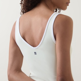 Model wearing Sweaty Betty tank in Butterscotch Yellow, back view showing deep V-neckline and small logo detail at centre back.
