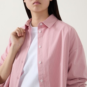 Model wearing Sweaty Betty Summer Stripe Shirt in Pink White Stripe, rear view showing beach-themed graphic print with bag, swimsuit and accessories