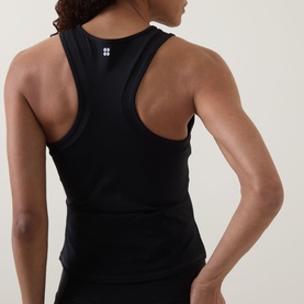 Model wearing Sweaty Betty black racerback tank top, rear view showing open back design and logo detail at neckline.