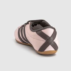 Adidas trainer in Sandy Pink with Earth Strata stripe detailing, leather upper, gum sole, rear three-quarter view.