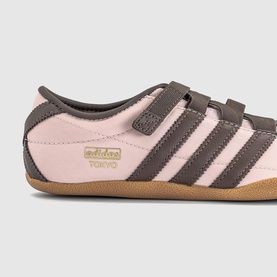 Adidas Tokyo trainers in Sandy Pink and Earth Strata, velcro strap fastening, gold branding, gum sole, side profile view.