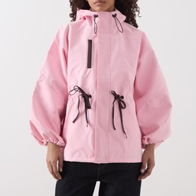Model wearing Damson Madder pink hooded coat with black drawstring waist ties and zip fastening, oversized silhouette.