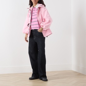 Model wearing Damson Madder pink polyester jacket, styled with a pink striped top and black wide-leg jeans.
