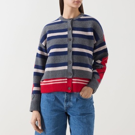 Model wearing Damson Madder Didi Layered Striped Cardigan in grey, navy, pink and red stripes with button front, styled with blue jeans.