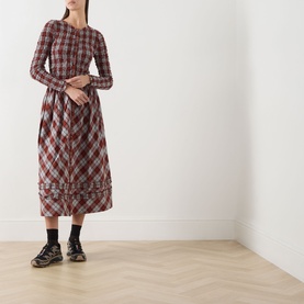 Model wearing Damson Madder Posey Smocked Check Dress in Blue Fog Multi Check; midi length, ruffle hem, styled with black chunky lace-up boots