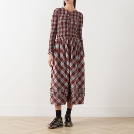 Model wearing Damson Madder Posey Smocked Check Dress in Blue Fog Multi Check, midi length with smocked bodice and ruffle hem, styled with black