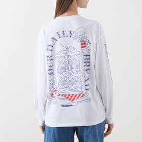 Model wearing Damson Madder white cotton long-sleeve T-shirt, back view, with burger graphic print and "Our Daily Bread" text design.