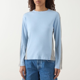 Model wearing Damson Madder blue long-sleeve cotton top with contrast grey side panels, styled with light blue denim jeans.