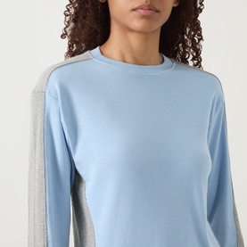 Model wearing Damson Madder blue long-sleeve cotton T-shirt with grey contrast side panels and crew neck.