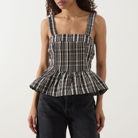 Model wearing Damson Madder yellow check peplum top with square neckline and wide straps, styled with dark jeans