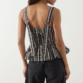 Model wearing Damson Madder yellow check sleeveless peplum top with ring-detail straps, styled with dark jeans, back view.