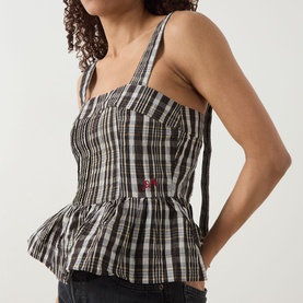 Model wearing Damson Madder yellow check sleeveless peplum top with square neckline, cross-back straps and floral button detail.