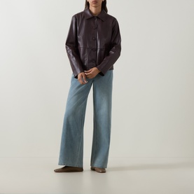 Model wearing Elena Miro Must faux leather jacket with collar and button front, styled with light blue wide-leg jeans and brown loafers