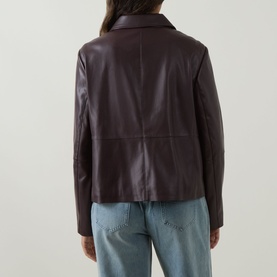 Model wearing Elena Miro jacket in Must, rear view, faux leather finish with notch collar, styled with light blue jeans
