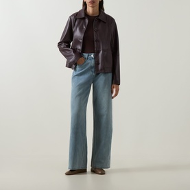 Model wearing Elena Miro must faux leather jacket with collar, styled with light blue wide-leg jeans and brown boots.