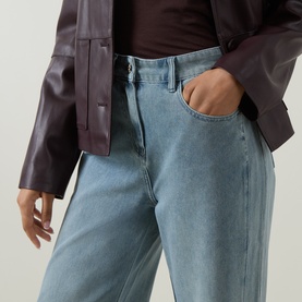 Model wearing Elena Miro Wide-Leg Jeans in light blue with high-rise fit and tobacco stitching, styled with a dark burgundy leather jacket.