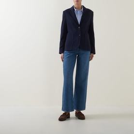Model wearing Gant Single-Breasted Piqu&eacute; Blazer in blue with notched lapels, styled with light blue jeans and brown loafers.