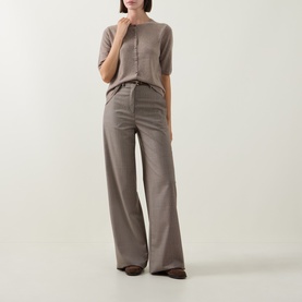Model wearing Gant Brushed Knitted Cardigan in Sand with crew neck, short sleeves and button front, styled with wide-leg trousers.