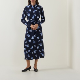 Model wearing Gant blue floral midi shirt dress with long sleeves, collared neckline, and self-tie waist belt, styled with black kitten heels