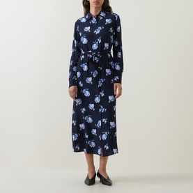 Model wearing Gant blue floral print midi shirt dress with long sleeves, tie waist, and button-down front, styled with black flat shoes.