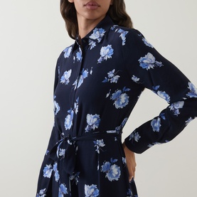 Model wearing Gant blue floral print shirt dress with tie waist, long sleeves, and collared neckline in navy and light blue blooms