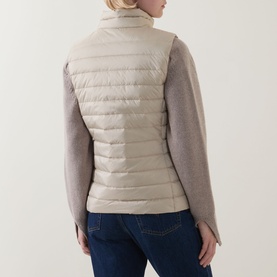 Model wearing Gant Logo Down-Filled Gilet in beige, styled with taupe knit sleeves and blue jeans, rear view showing straight hem and stand-up collar