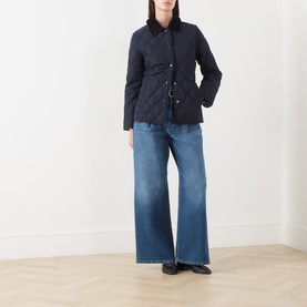 Model wearing Gant Quilted Fitted Jacket in blue with corduroy collar, styled with wide-leg jeans and black loafers.