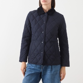 Model wearing Gant Quilted Fitted Jacket in blue with corduroy-trimmed collar and snap button fastenings, styled with light blue jeans.