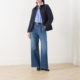 Model wearing Gant Quilted Fitted Jacket in blue with corduroy collar, styled with light blue shirt, wide-leg jeans and black loafers.