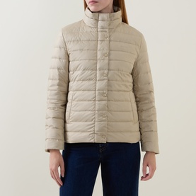 Model wearing Gant Light Logo Down Jacket in beige, lightweight quilted down-fill, stand collar, snap-buttoned placket, styled with dark jeans