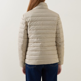 Model wearing Gant Light Logo Down Jacket in beige, back view, showing quilted panels and stand collar, styled with blue jeans