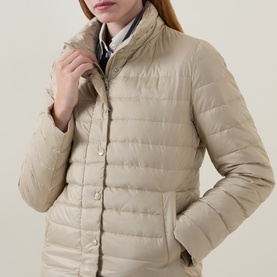Model wearing Gant Light Logo Down Jacket in beige, lightweight quilted down-fill, snap-button placket, stand collar, styled with striped collar