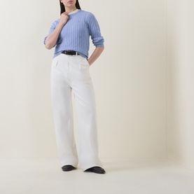 Model wearing Gant Shield Logo Cable Knit Sweater in lavender with crew neck, styled with wide-leg white trousers and black belt.