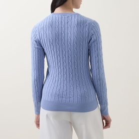Model wearing Gant Shield Logo Cable Knit Sweater in lavender, back view showing cable knit pattern and crew neckline, styled with white trousers.