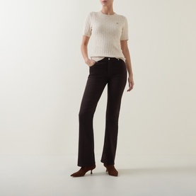 Model wearing Gant beige short-sleeve ribbed knit top, styled with dark flared trousers and brown heels.