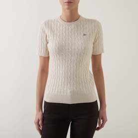 Model wearing Gant beige cotton cable-knit short-sleeve jumper with crew neck and small logo badge, styled with dark trousers