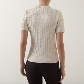 Model wearing Gant beige cable-knit short-sleeve jumper, back view, styled with dark tailored trousers.