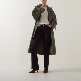 Model wearing Gant beige knit, styled with olive belted trench coat, dark trousers and burgundy heeled boots.
