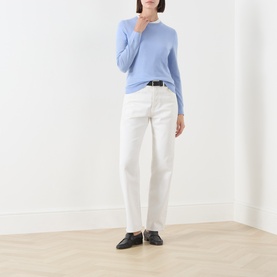 Model wearing Gant Merino Knitted Sweater in lavender with crew neck, styled with white trousers and black loafers.