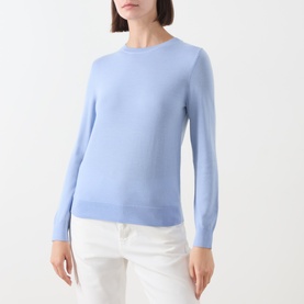 Model wearing Gant Merino Knitted Sweater in lavender with crew neckline, long sleeves and ribbed trims, styled with white trousers.