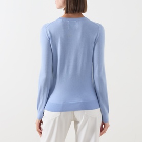 Model wearing Gant Merino Knitted Sweater in lavender, crew neck, long sleeves, ribbed trims, styled with white trousers. Back view.