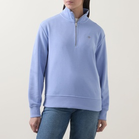 Model wearing Gant Shield Logo Half-Zip Sweatshirt in lavender, featuring funnel neck, half-zip and shield logo. Styled with blue jeans.