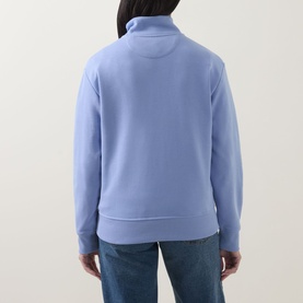 Model wearing Gant Shield Logo Half-Zip Sweatshirt in lavender, back view, funnel neck half-zip, styled with blue jeans.