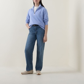Model wearing Gant Shield Logo Half-Zip Sweatshirt in lavender with half-zip funnel neck, styled with wide-leg jeans and flat shoes.